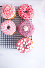 Five cute pink donuts on white background