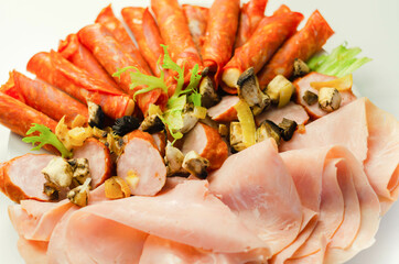 A cold plate prepared for the party with sliced chorizo, ham and sausages