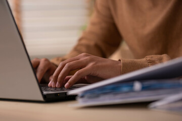 Close up hand.Business asian man types and works online on a desk table with a laptop.