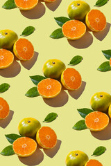 Colorful fruit pattern of fresh mandarins on yellow background