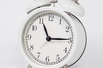 White vintage alarm clock on a white background, close-up, important affairs