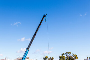 空に向かってブームを伸ばすクレーン