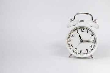 White vintage alarm clock on white background, place for text