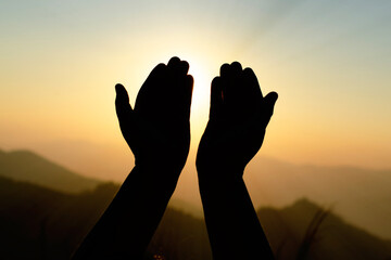 Woman hands holding the sun at dawn. Freedom and spirituality concept.