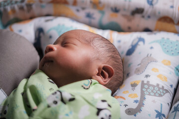 A newborn baby is sleeping comfortably with an adorable expression. Asian child two days old. 