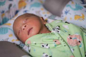 A newborn baby is sleeping comfortably with an adorable expression. Asian child two days old. 