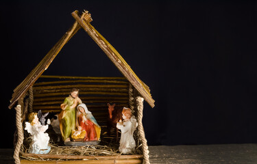 Christmas nativity scene for home decoration with figures of Jesus, Virgin Mary and Joseph on a dark background with selective focus