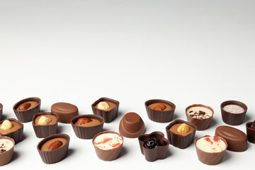 Flat lay composition with chocolate candies on white background