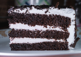 Close up of a slice of Black Forest cake on a white plate.