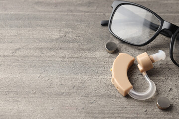 Concept of health care with hearing aid on gray wooden background