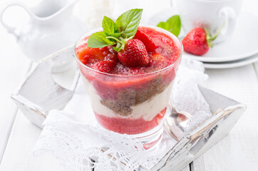 Traditional sweet strawberry dessert with yogurt served as close-up in a glass