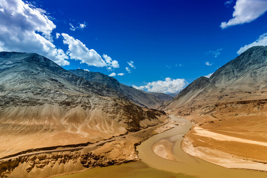 Scenic view of Confluence of Zanskar river from left and Indus rivers from up right - Leh, Ladakh, Jammu and Kashmir, India. Famous tourist spot of Ladakh landscape. Union territory of India.