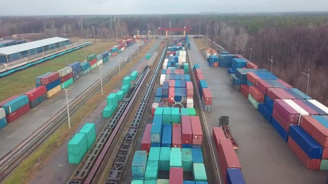 Multicolored freight containers at the railway customs. Aerial drone flight over.