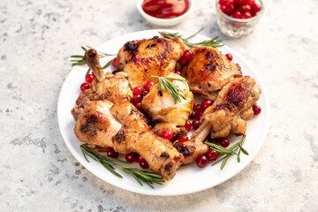 Various pieces of turkey baked with cranberries and rosemary on a stone background.