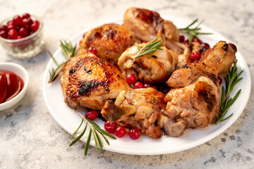 Various pieces of turkey baked with cranberries and rosemary on a stone background.