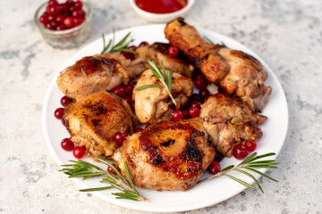 Various pieces of turkey baked with cranberries and rosemary on a stone background.