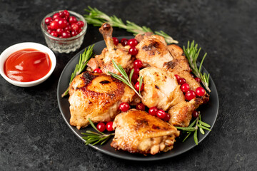 Various pieces of turkey baked with cranberries and rosemary on a stone background.