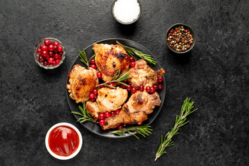 Various pieces of turkey baked with cranberries and rosemary on a stone background.