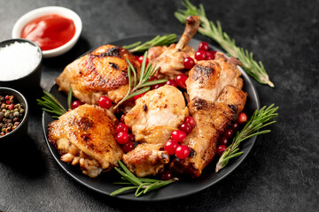 Various pieces of turkey baked with cranberries and rosemary on a stone background.