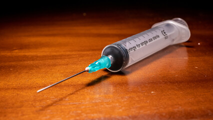 Syringe ready for vaccination on a wooden surface