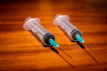 Two syringes ready for vaccination on a wooden surface