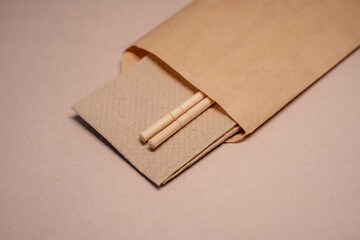 close-up of chinese sticks in craft paper packaging on beige background