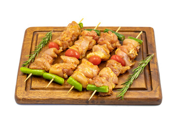 Raw chicken skewers isolated on white background. Close-up of raw chicken skewers marinated in tomato sauce. Horizontal view.