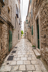 Fototapeta na wymiar Narrow old town street at Sibenik city, Croatia. Famous tourist destination.