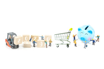 selective focus of miniature worker man standing front of piggy bank on white background