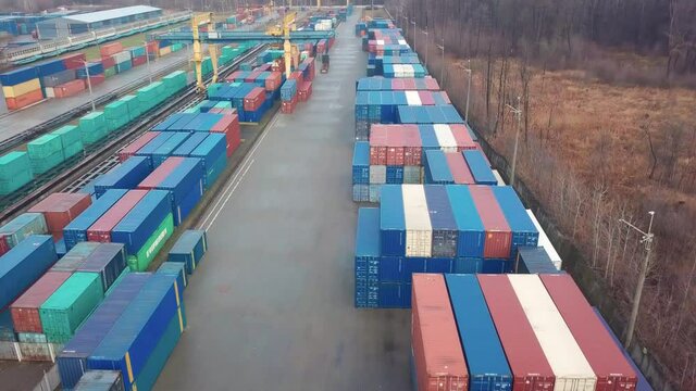 Multicolored freight containers at the railway customs. Aerial drone flight over.