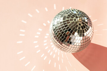 Minimal creative Christmas decorations, mirror disco balls on sand color background.