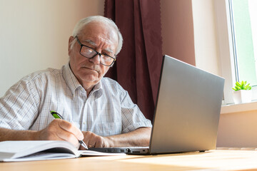 senior old man male sit next at desk, home office online notebook laptop work business distance freelancer