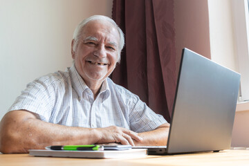 Fototapeta premium senior old man male sit next at desk, home office online notebook laptop work business distance freelancer