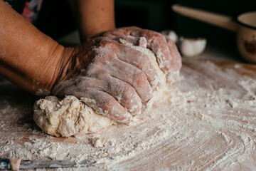 hands close-up kneading dough on a wooden board