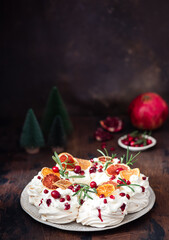 Meringues pavlova cake wreath with whipped  cream, pomegranate and orange