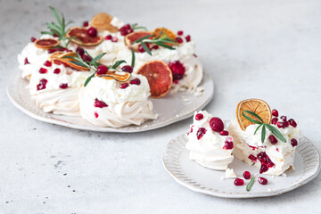 Meringues pavlova cake wreath with whipped  cream, pomegranate and orange