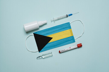 Blood tube for test detection of virus Covid-19 Omicron Variant with positive result, medicine mask with Bahamas flag superimposed and vaccine.  New Variant of the Covid-19 Omicron - 475726599