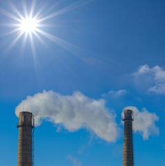 industry pipe with smoke on blue sky background at suny day