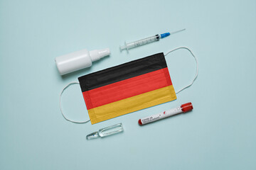 Blood tube for test detection of virus Covid-19 Omicron Variant with positive result, medicine mask with Germany flag superimposed and vaccine.  New Variant of the Covid-19 Omicron - 475727374