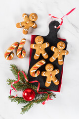 Christmas Gingerbread Man. Holiday  honey ginger cookies with cinnamon and nutmeg on a serving board on a red linen napkin on a light background. Top view