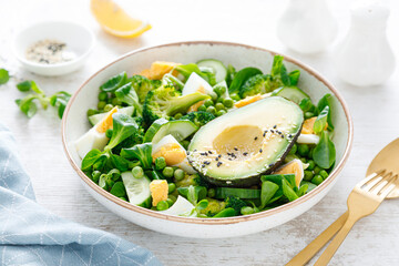 Easter fresh vegetable salad with boiled egg, broccoli, corn salad, green peas and avocado
