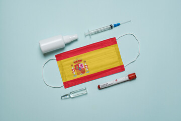Blood tube for test detection of virus Covid-19 Omicron Variant with positive result, medicine mask with Spain flag superimposed and vaccine.  New Variant of the Covid-19 Omicron - 475727978