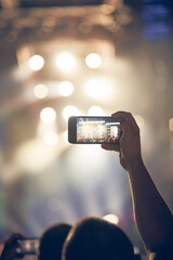 Person holding modern smartphone on a concert.