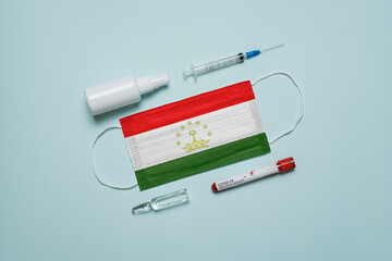 Blood tube for test detection of virus Covid-19 Omicron Variant with positive result, medicine mask with Tajikistan flag superimposed and vaccine.  New Variant of the Covid-19 Omicron