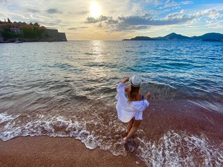 girl on the beach enjoys the beauty of nature on a sunset, recreation concept, amazing view, human...