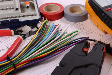 Electrical tools, multimeter, colored wires on the electrical diagram.