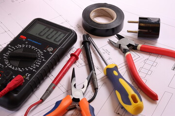 Electrical tools, multimeter, colored wires on the electrical diagram.