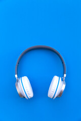 Fototapeta na wymiar Wireless headphones on blue background. Space for text.