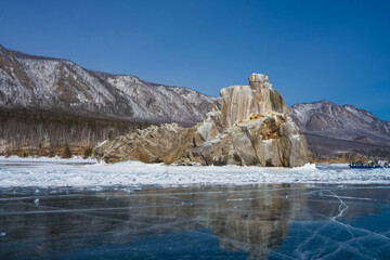 Fototapeta na wymiar transparent ice on Lake Baikal against the background of mountains