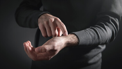 Man checking heart rate pulse on wrist.